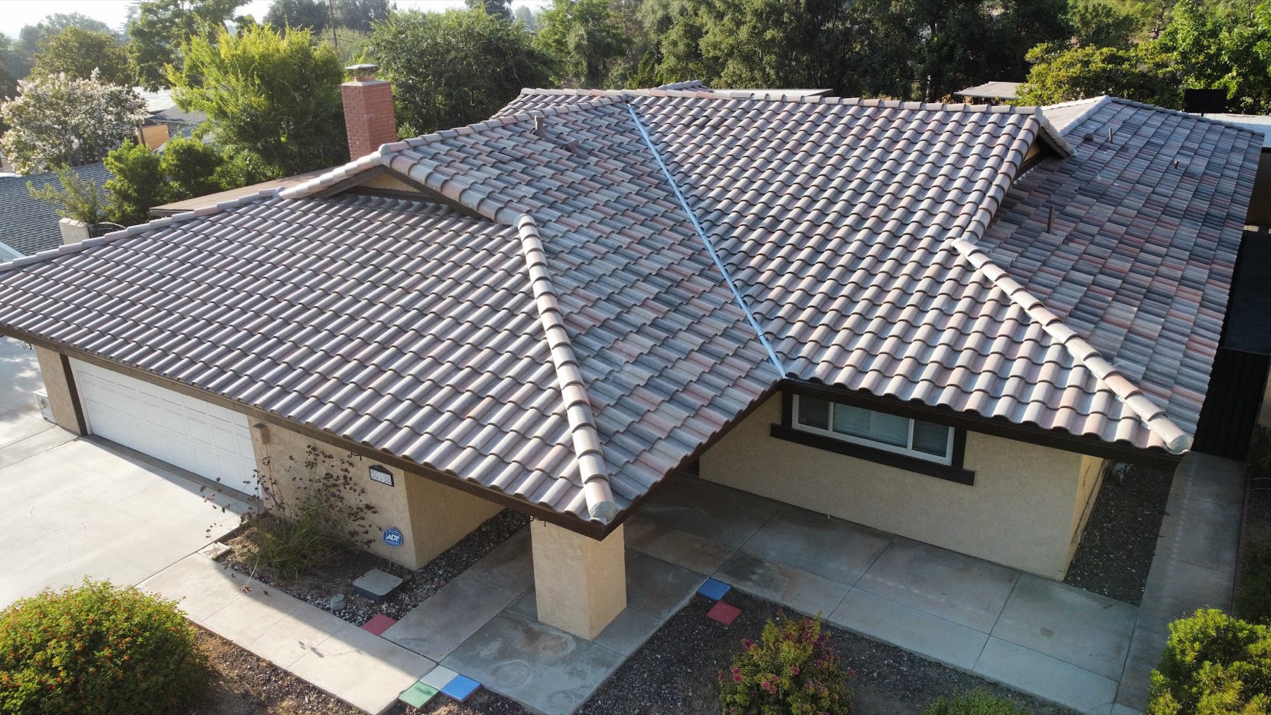 An overhead view of a single-story ranch house finished in charcoal concrete roof tile.